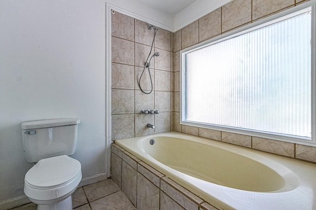 bathroom featuring tiled shower / bath, baseboards, toilet, and a wealth of natural light