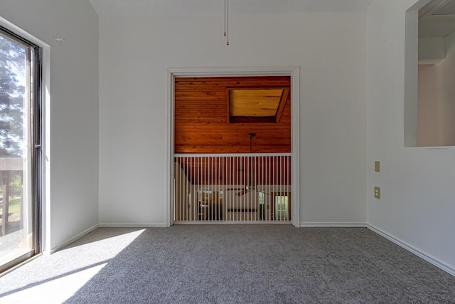 carpeted empty room featuring baseboards