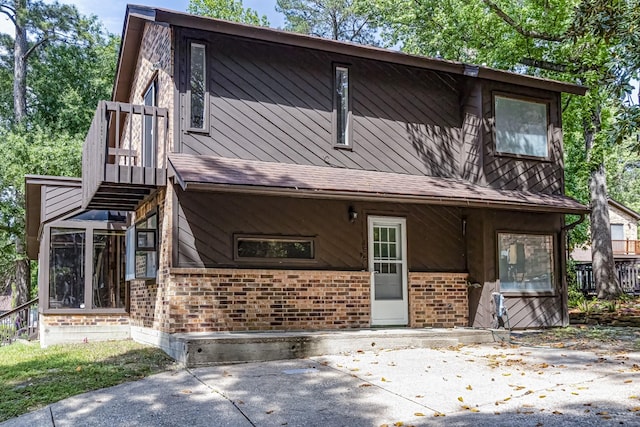 view of front facade with brick siding and a patio