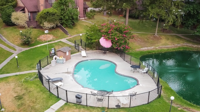 pool featuring a patio area, a lawn, and fence