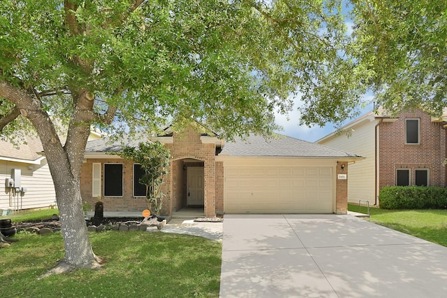 view of front of house featuring driveway, an attached garage, a front yard, brick siding, and roof with shingles