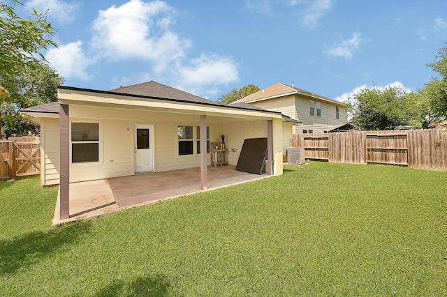 rear view of property with roof with shingles, a fenced backyard, cooling unit, a lawn, and a patio