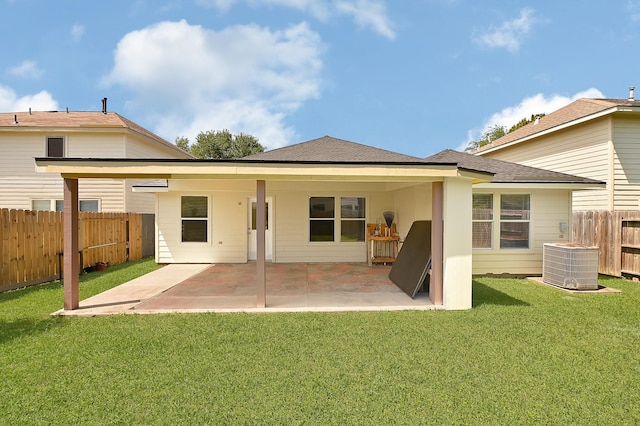 rear view of property featuring fence, a lawn, a patio area, and central AC unit