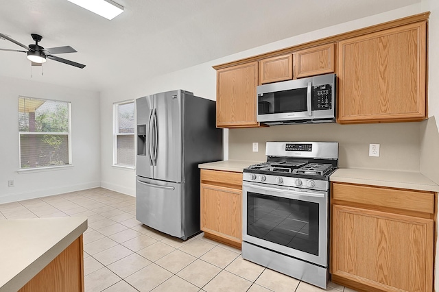 kitchen with stainless steel appliances, light countertops, a ceiling fan, light tile patterned floors, and baseboards
