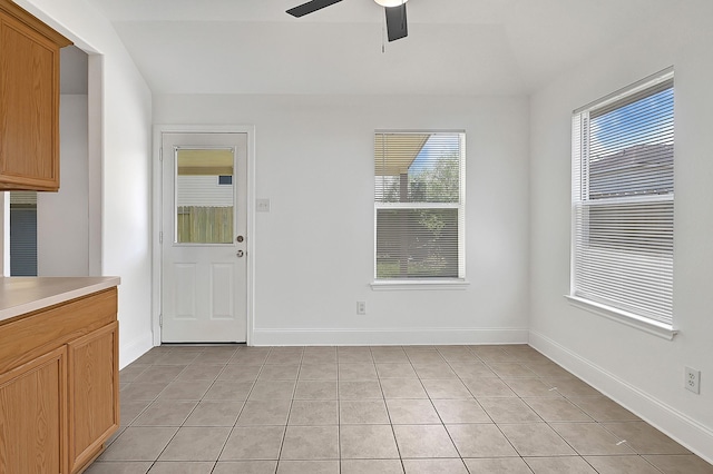 interior space featuring ceiling fan, baseboards, and light tile patterned floors