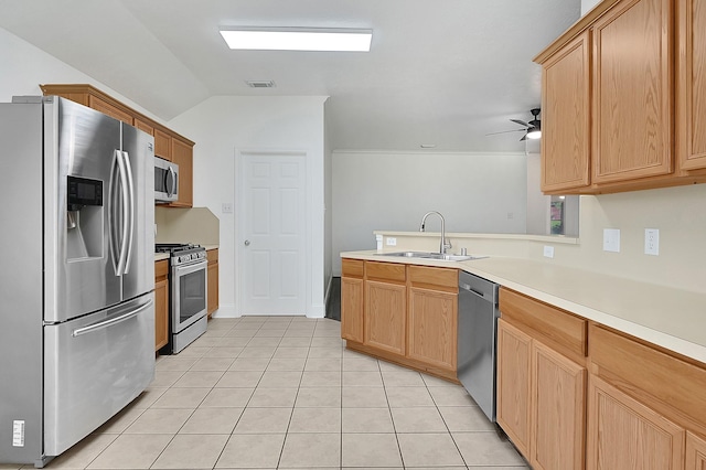 kitchen with stainless steel appliances, a peninsula, a sink, light countertops, and light tile patterned floors