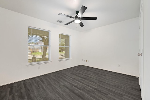 unfurnished room featuring dark wood finished floors, visible vents, and a ceiling fan