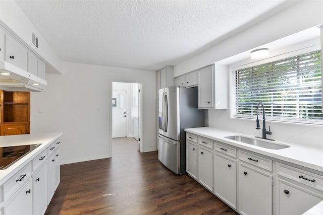 kitchen featuring a sink, a textured ceiling, stainless steel fridge with ice dispenser, black electric cooktop, and light countertops