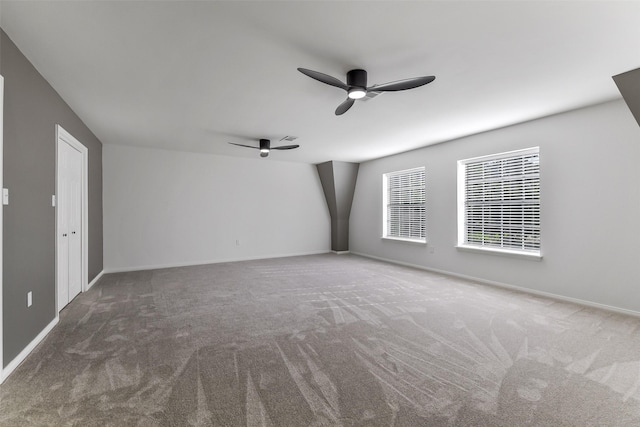 carpeted empty room with baseboards, a ceiling fan, and visible vents