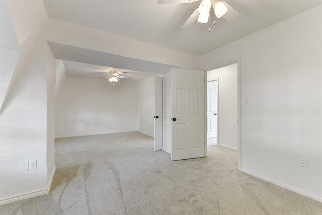 unfurnished room with a ceiling fan, baseboards, and carpet