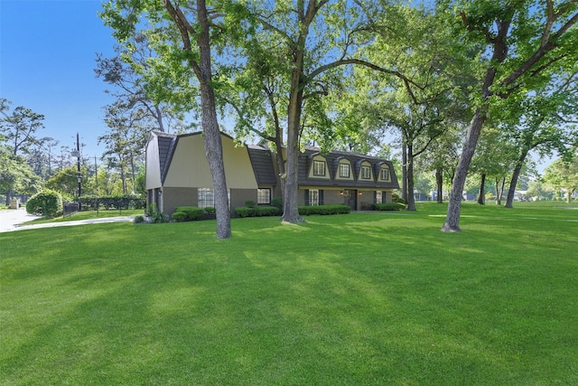 exterior space with brick siding and a front yard