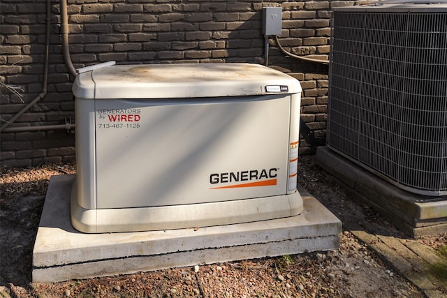 details featuring a power unit, brick siding, and cooling unit