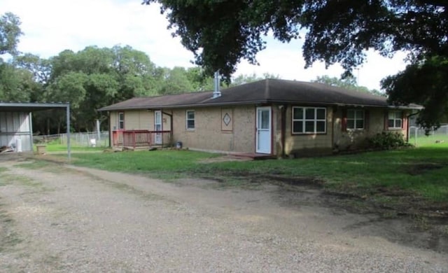exterior space featuring a wooden deck, a yard, and driveway