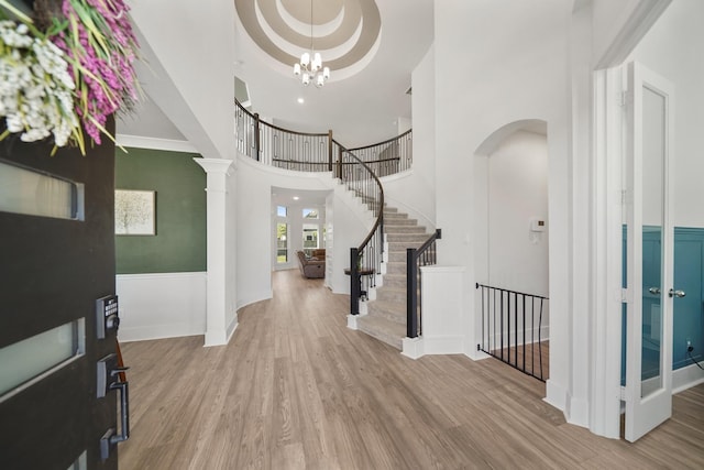 foyer entrance with baseboards, wood finished floors, a towering ceiling, and stairs