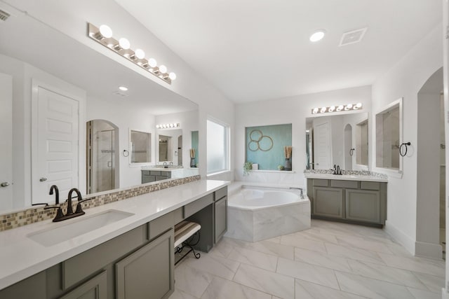 full bathroom with a garden tub, visible vents, a sink, and a shower stall