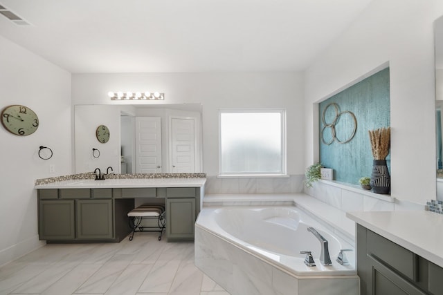 bathroom featuring a garden tub, vanity, and visible vents