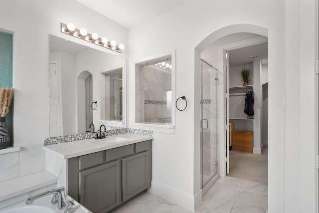 bathroom with baseboards, marble finish floor, vanity, and a stall shower