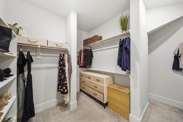walk in closet featuring light carpet