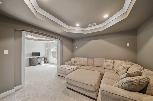 living room with recessed lighting, a tray ceiling, visible vents, baseboards, and light colored carpet