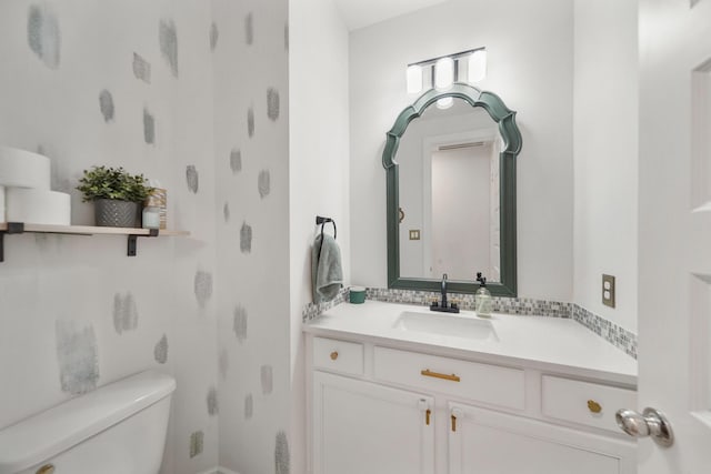 bathroom featuring vanity and toilet
