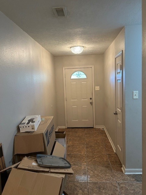 entryway with a textured ceiling and baseboards