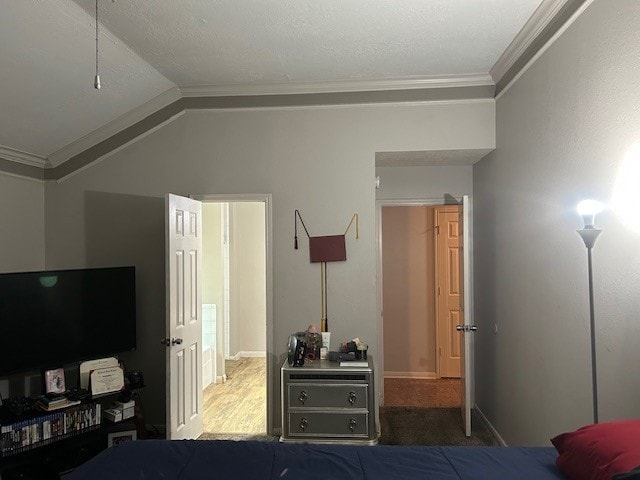 bedroom with crown molding, lofted ceiling, and baseboards