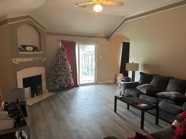 living room featuring vaulted ceiling, a ceiling fan, wood finished floors, a fireplace with flush hearth, and baseboards