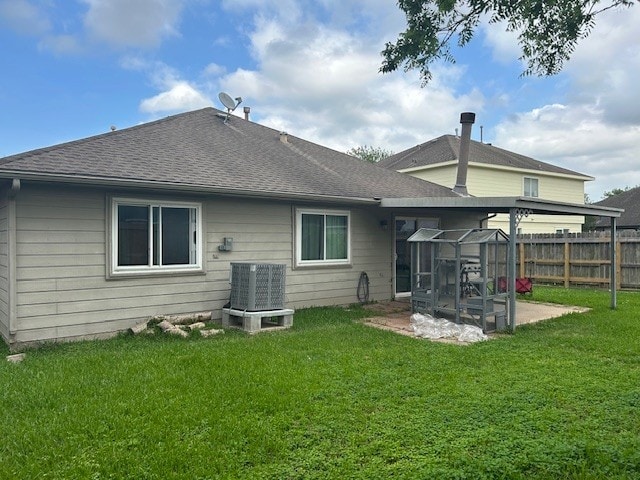 back of property featuring central AC, a shingled roof, and a sunroom