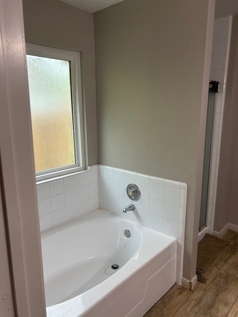 full bath with wood finished floors, a garden tub, and a shower with shower door
