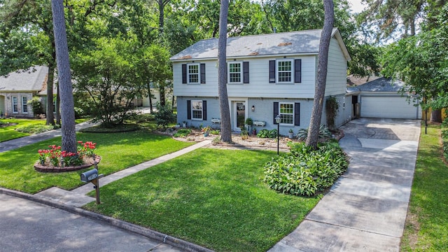 colonial house with concrete driveway, a front lawn, brick siding, and a garage