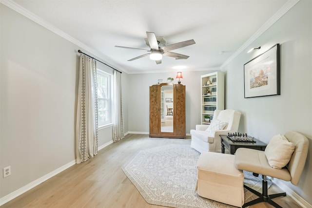 living area featuring ornamental molding, baseboards, a ceiling fan, and light wood finished floors