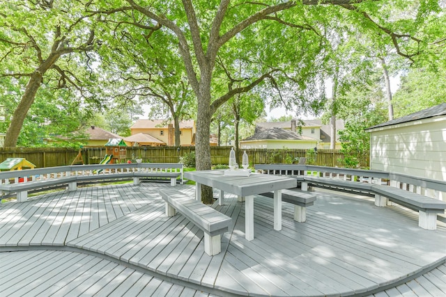 deck with a fenced backyard, playground community, a residential view, and outdoor dining area