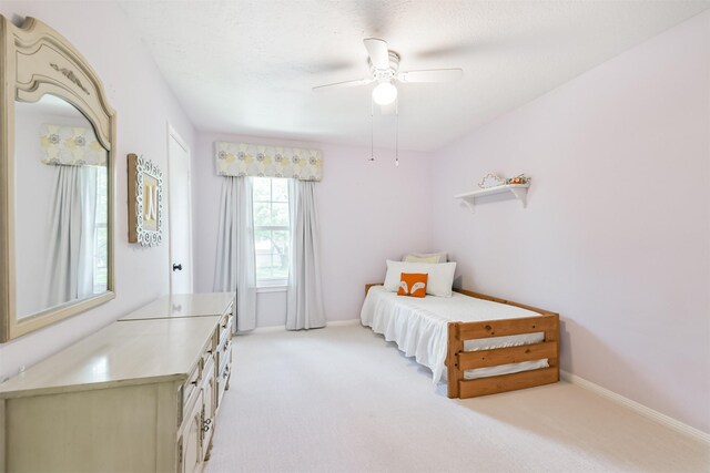 bedroom featuring a ceiling fan, baseboards, and light carpet
