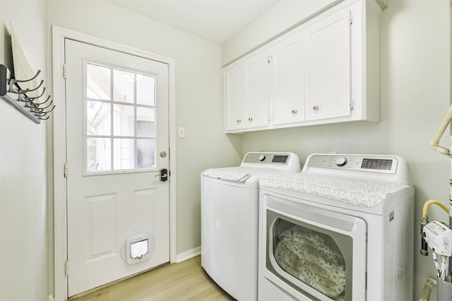 laundry room featuring cabinet space, light wood-style floors, and washer and dryer