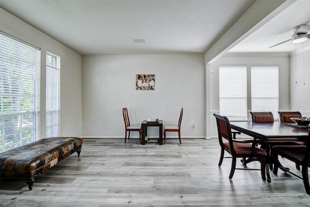 dining area featuring plenty of natural light, wood finished floors, a ceiling fan, and baseboards