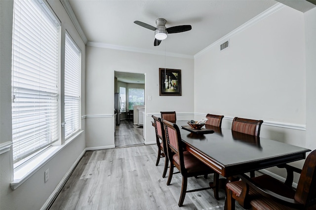 dining room featuring a ceiling fan, light wood-style flooring, ornamental molding, and baseboards