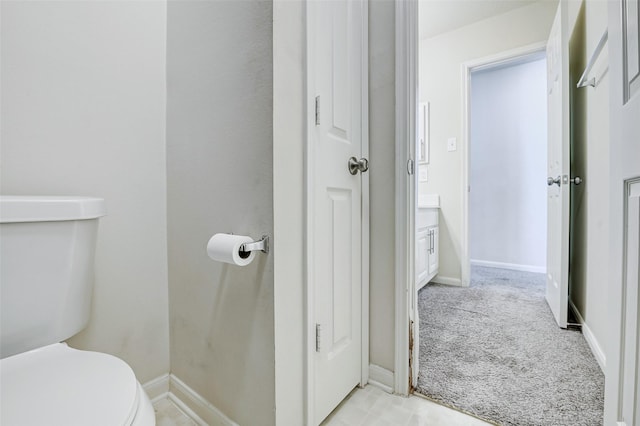 half bathroom featuring toilet and baseboards