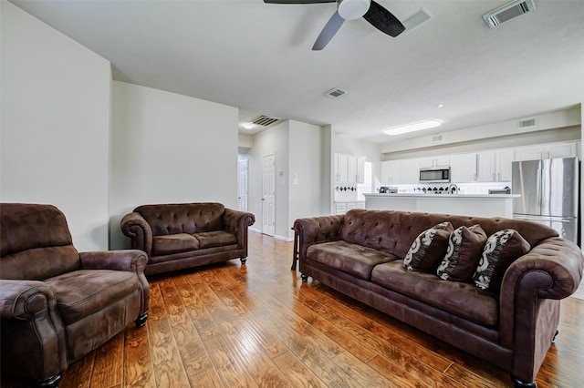living room featuring hardwood / wood-style floors and ceiling fan