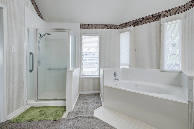 bathroom with wallpapered walls, a shower stall, vaulted ceiling, a garden tub, and baseboards