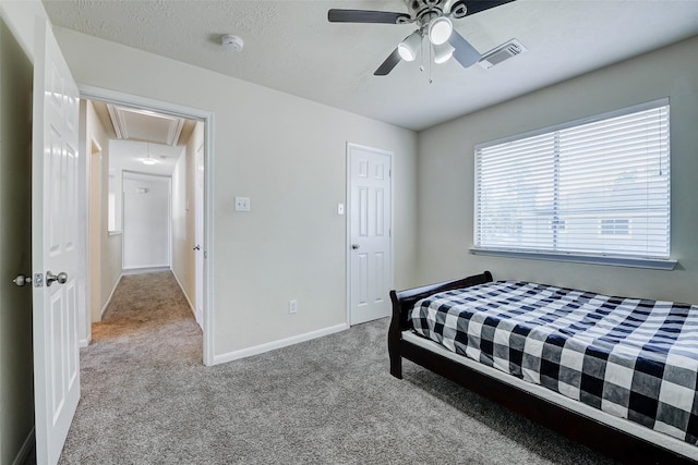 bedroom featuring attic access, carpet flooring, baseboards, and a ceiling fan