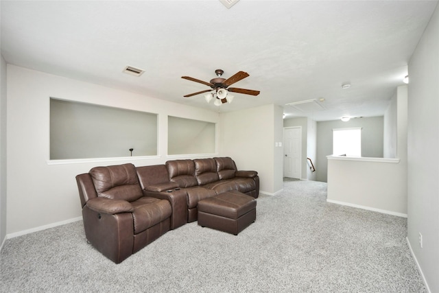 carpeted living room featuring attic access, baseboards, a ceiling fan, and visible vents