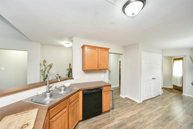kitchen with baseboards, light wood-style floors, a sink, and dishwasher