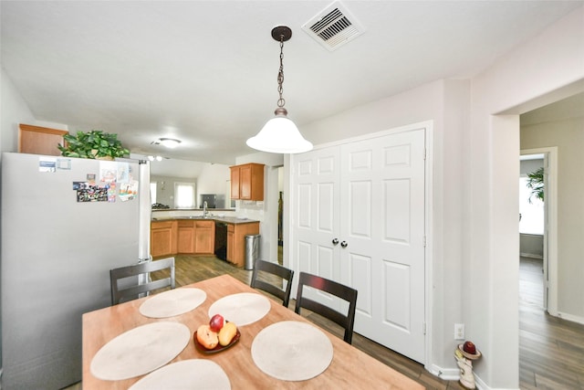 dining space featuring baseboards, visible vents, and dark wood finished floors
