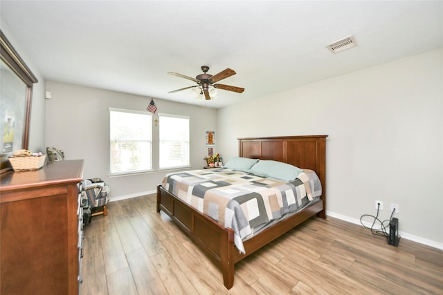 bedroom featuring ceiling fan, baseboards, visible vents, and light wood-style floors