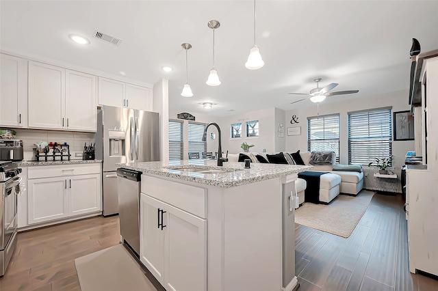 27946 Western Creek Ct, Katy, TX 77494 - kitchen featuring a ceiling fan, a sink, open floor plan, stainless steel appliances, and visible vents