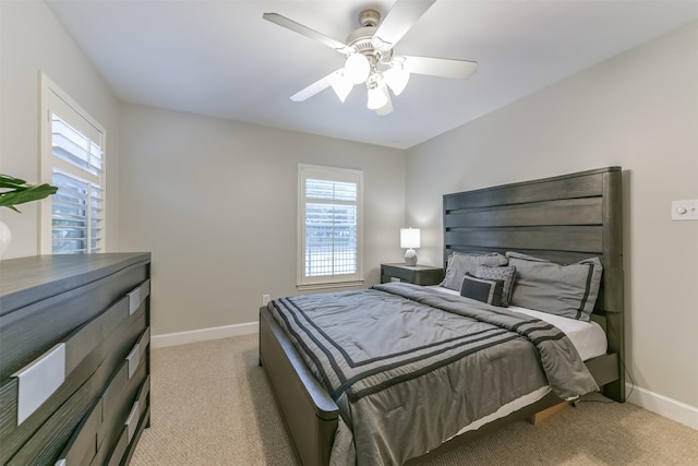 bedroom featuring baseboards, multiple windows, and light carpet