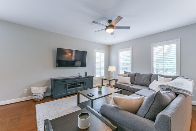 living room with baseboards, ceiling fan, and wood finished floors