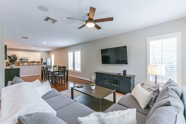living area featuring a ceiling fan, visible vents, wood finished floors, baseboards, and recessed lighting