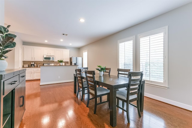 dining space featuring baseboards, recessed lighting, wood finished floors, and visible vents