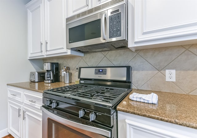 kitchen featuring white cabinets, appliances with stainless steel finishes, and tasteful backsplash